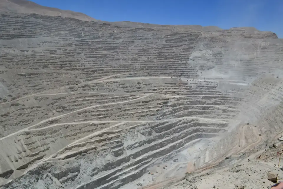 Paredes de un rajo abierto con bancos escalonados y caminos de acceso bajo cielo despejado